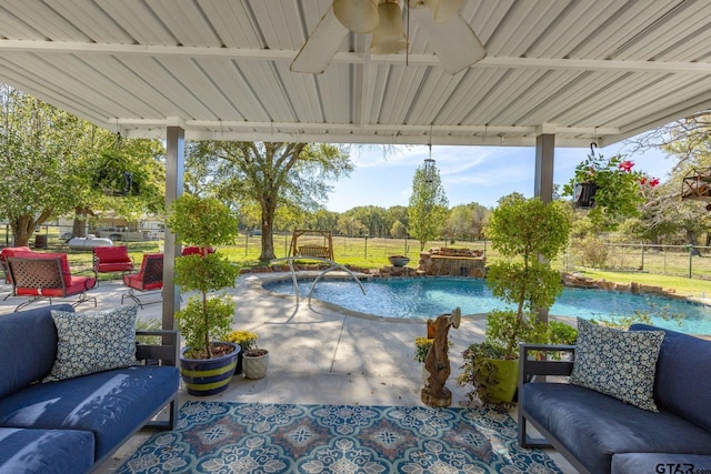 view of swimming pool featuring pool water feature, ceiling fan, an outdoor hangout area, and a patio