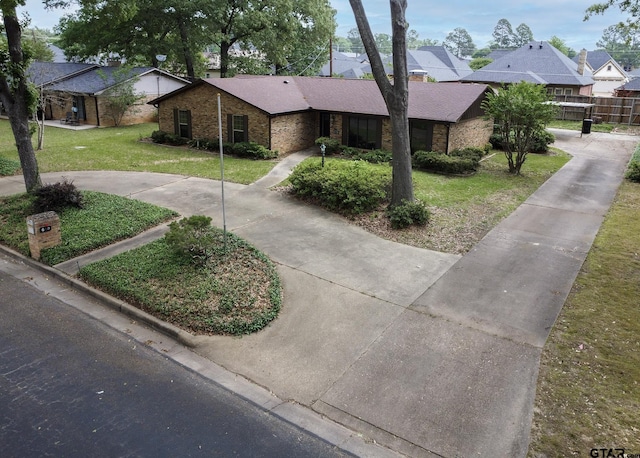 ranch-style house with brick siding, a residential view, and a front lawn