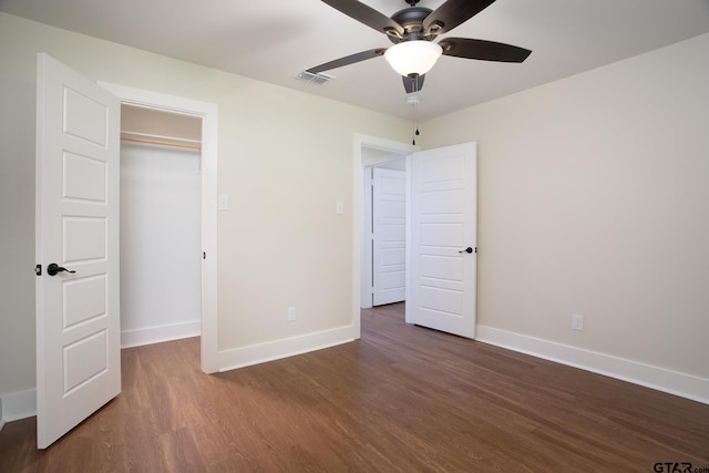 unfurnished bedroom featuring a ceiling fan, baseboards, visible vents, and wood finished floors