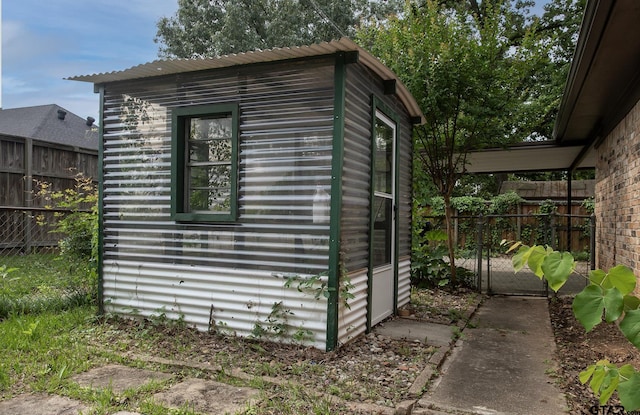 view of outbuilding featuring fence, an outbuilding, and a gate