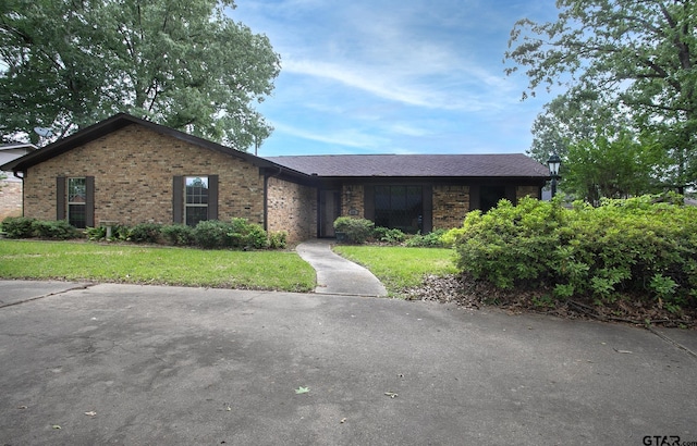 single story home with brick siding and a front lawn