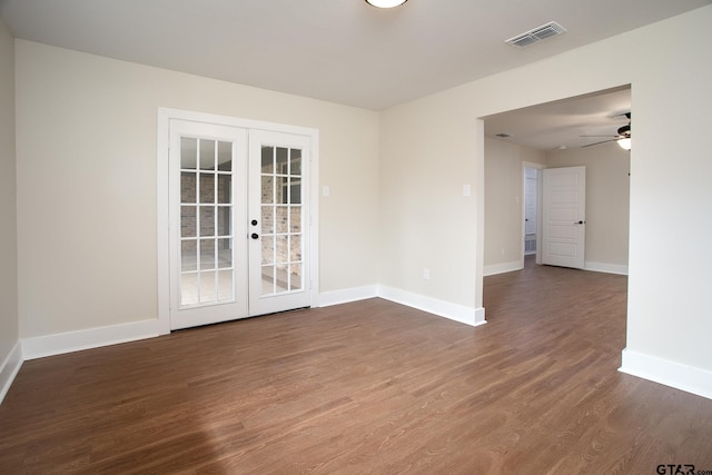 empty room with baseboards, visible vents, french doors, and wood finished floors