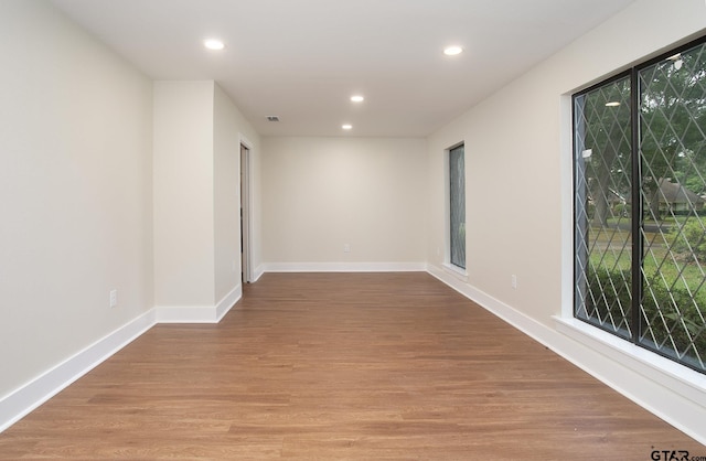 empty room featuring recessed lighting, baseboards, wood finished floors, and visible vents