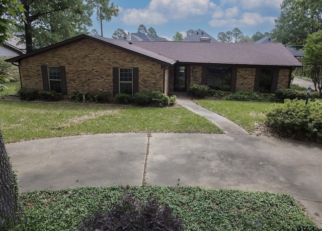 ranch-style house featuring brick siding and a front yard