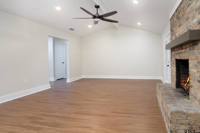 unfurnished living room featuring a fireplace, a ceiling fan, wood finished floors, vaulted ceiling with beams, and visible vents