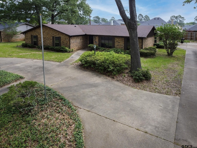 single story home with a front lawn and brick siding