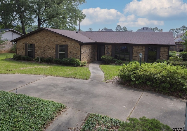 ranch-style home with brick siding and a front yard