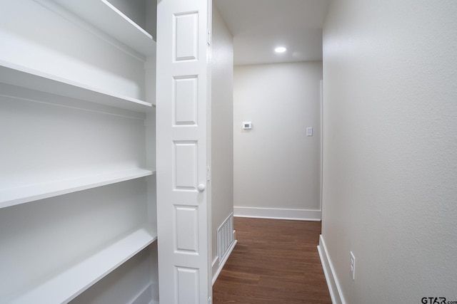 corridor with baseboards, recessed lighting, and dark wood finished floors