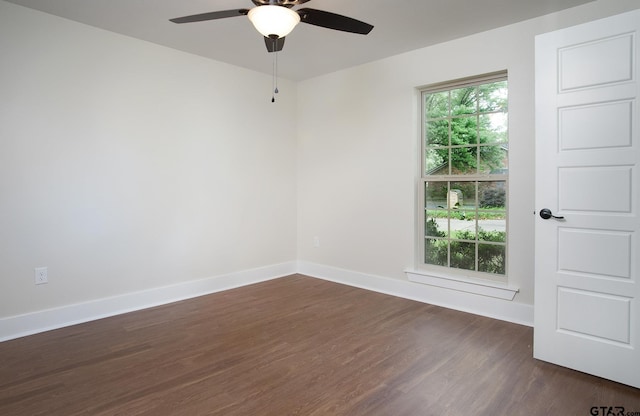 unfurnished room with baseboards, ceiling fan, and dark wood-style floors