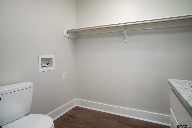 interior space with toilet, baseboards, wood finished floors, and vanity