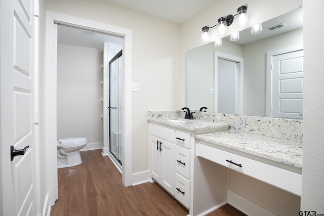 full bathroom with visible vents, a stall shower, wood finished floors, vanity, and toilet