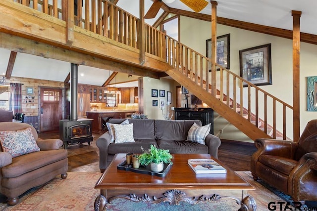 16887 Rainbow Ridge Cir, Tyler, TX 75707 - living room featuring a wood stove, wood finished floors, stairway, high vaulted ceiling, and beam ceiling