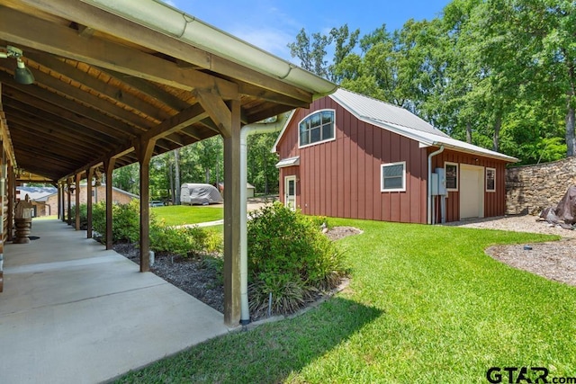 16887 Rainbow Ridge Cir, Tyler, TX 75707 - view of side of home with board and batten siding, a yard, a garage, and a metal roof