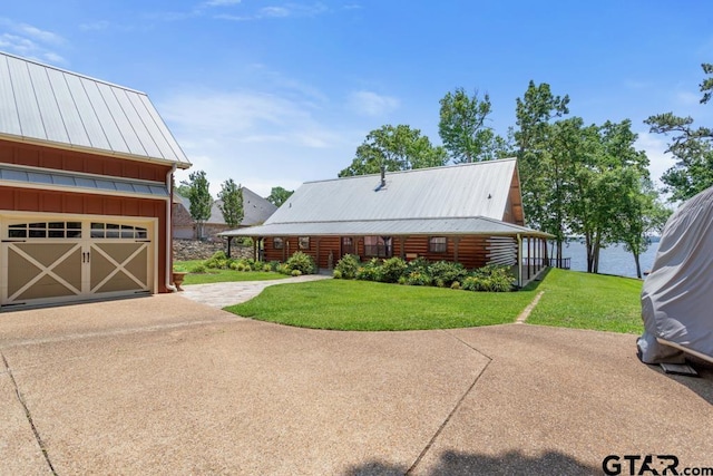 16887 Rainbow Ridge Cir, Tyler, TX 75707 - view of front of property with a front lawn, concrete driveway, board and batten siding, a garage, and a metal roof
