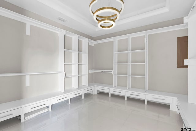 mudroom with an inviting chandelier, electric panel, crown molding, a tray ceiling, and light tile patterned floors