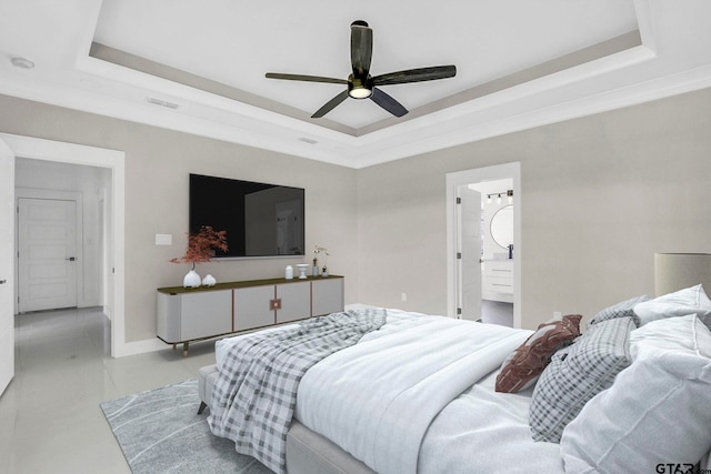 bedroom featuring a raised ceiling, connected bathroom, ceiling fan, and ornamental molding