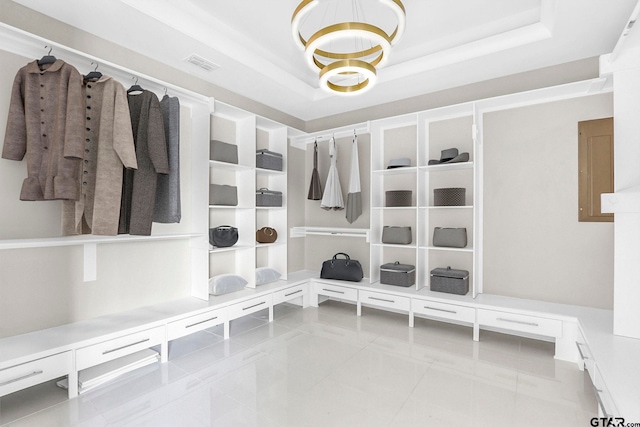 walk in closet featuring light tile patterned flooring and a raised ceiling