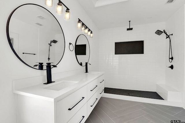 bathroom with vanity and a tile shower