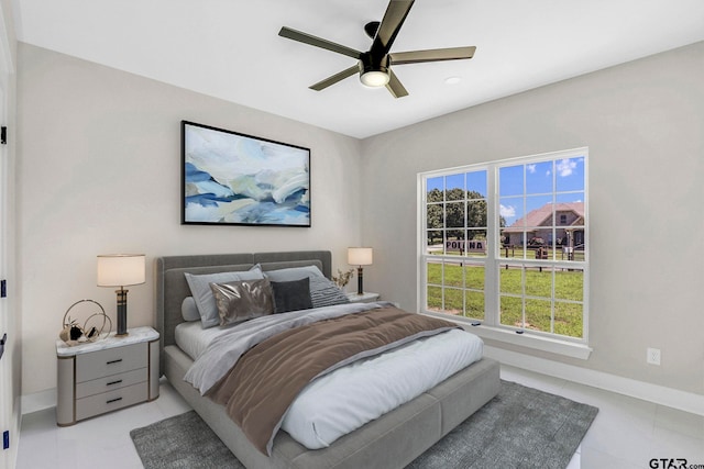 bedroom featuring multiple windows, ceiling fan, and light tile patterned floors