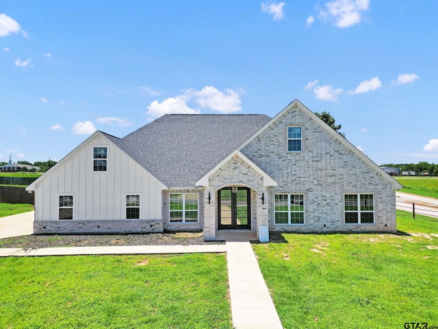 view of front facade with a front yard and french doors