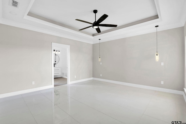 spare room featuring a tray ceiling and ceiling fan