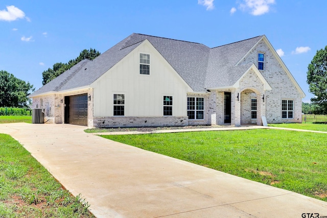 view of front of property featuring cooling unit, a garage, and a front yard