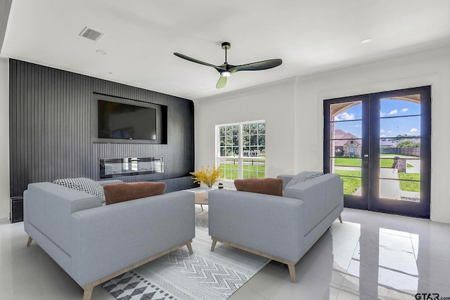 living room with french doors, light tile patterned floors, ceiling fan, and ornamental molding