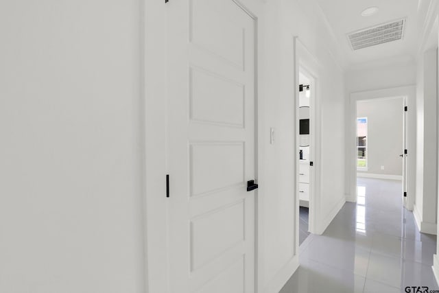 hall with light tile patterned floors and crown molding