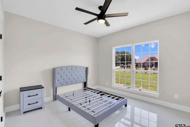 bedroom featuring multiple windows, light tile patterned floors, and ceiling fan