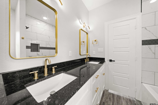 bathroom with tiled shower / bath combo, vanity, and hardwood / wood-style flooring