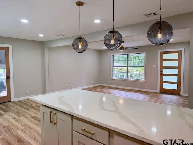 1113 Swanson Dr, Palestine, TX 75801 - kitchen featuring light wood-type flooring, pendant lighting, open floor plan, recessed lighting, and light stone counters