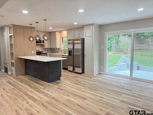 1113 Swanson Dr, Palestine, TX 75801 - kitchen with appliances with stainless steel finishes, a peninsula, a sink, light wood-style floors, and recessed lighting