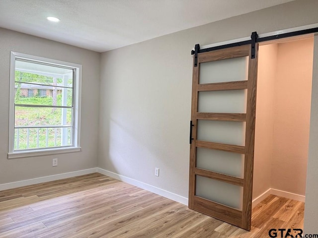 1113 Swanson Dr, Palestine, TX 75801 - spare room featuring a barn door, light wood-type flooring, baseboards, and recessed lighting