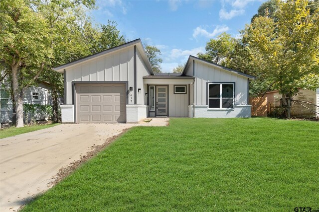 view of front of home with a garage and a front lawn