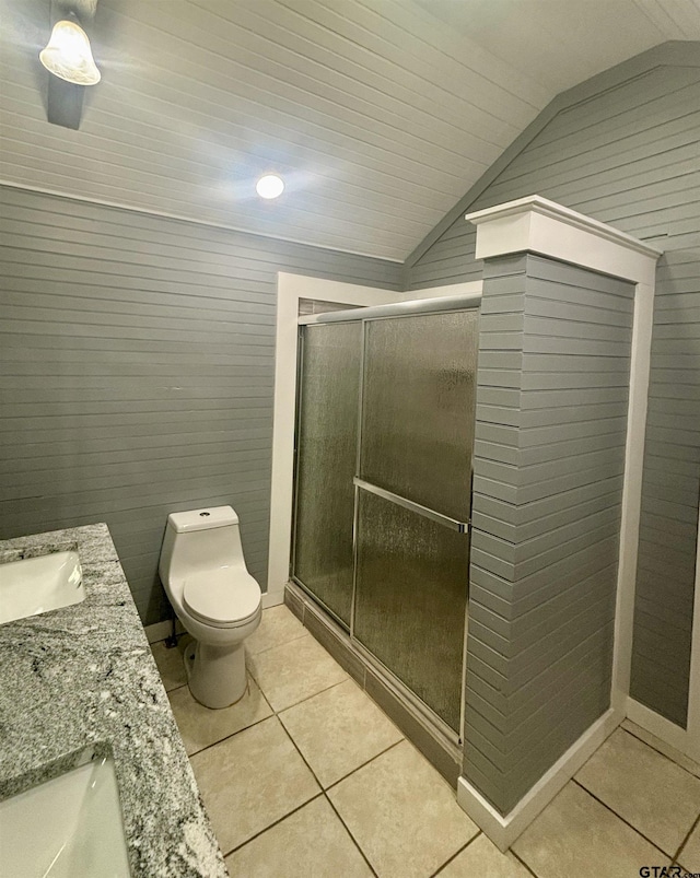 bathroom featuring lofted ceiling, tile patterned flooring, an enclosed shower, vanity, and toilet