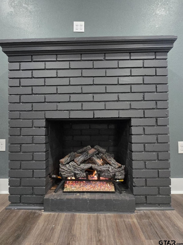 room details with a brick fireplace and hardwood / wood-style flooring