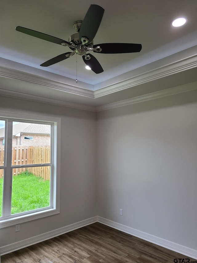 empty room with ceiling fan, hardwood / wood-style flooring, ornamental molding, and a raised ceiling