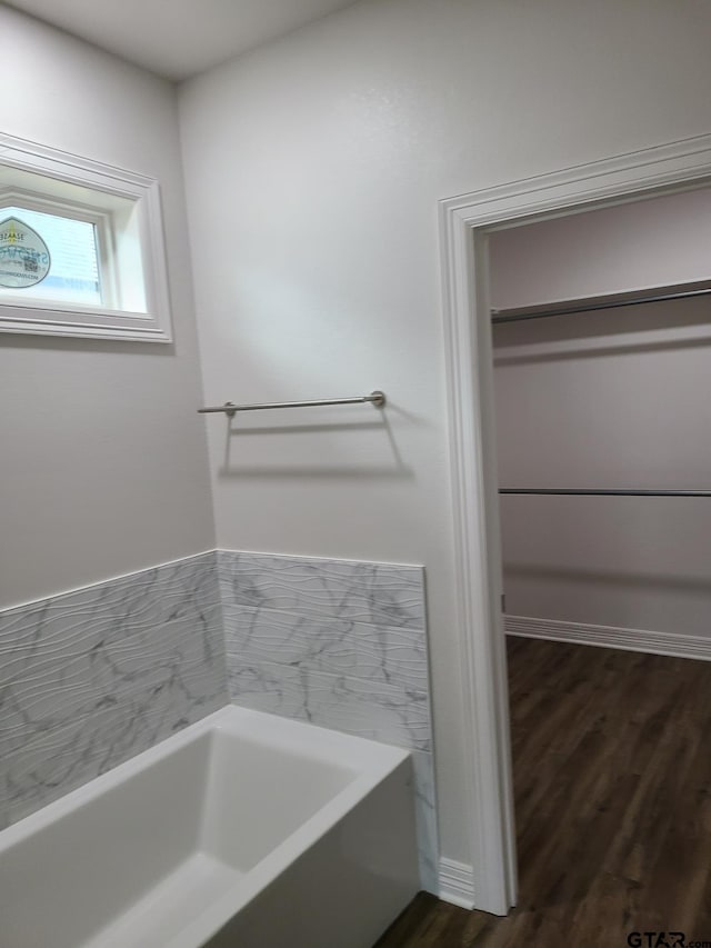 bathroom featuring a bath and hardwood / wood-style flooring