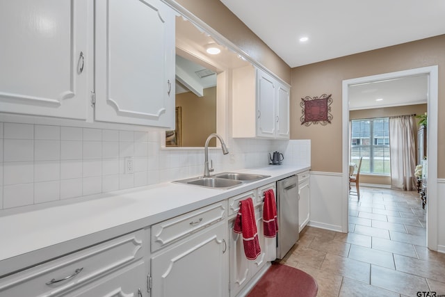 kitchen with backsplash, sink, dishwasher, white cabinetry, and light tile patterned flooring