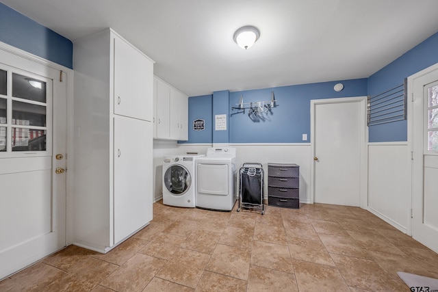 clothes washing area with wood walls, cabinets, and independent washer and dryer