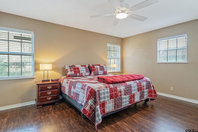 bedroom with multiple windows, ceiling fan, and dark hardwood / wood-style flooring