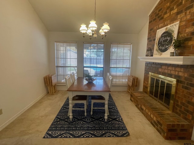 dining space with carpet flooring, a chandelier, vaulted ceiling, and a brick fireplace