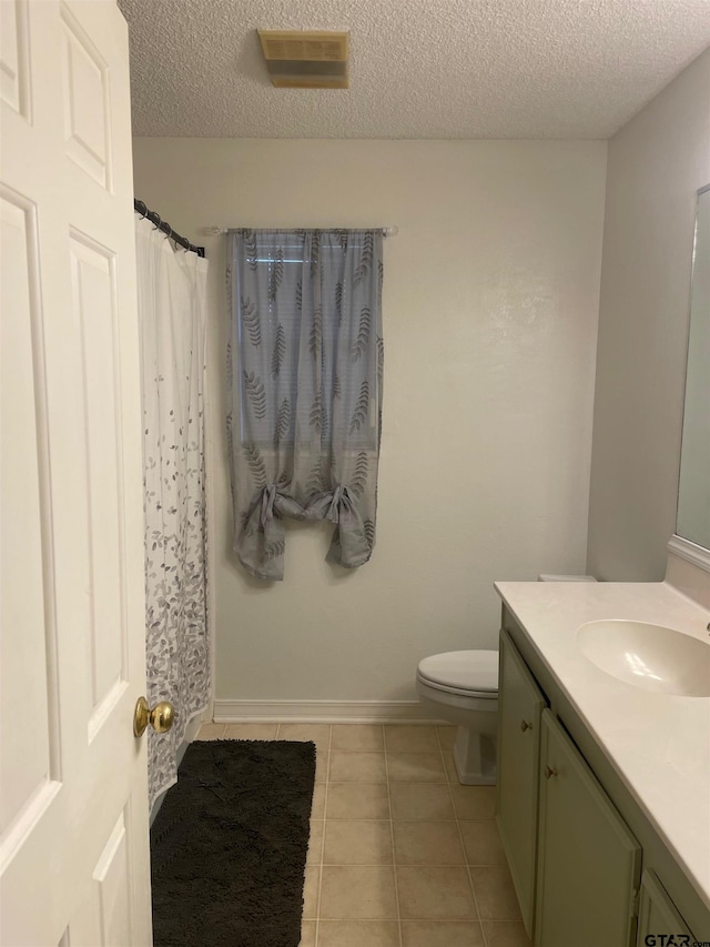 bathroom with vanity, tile patterned floors, a textured ceiling, and toilet