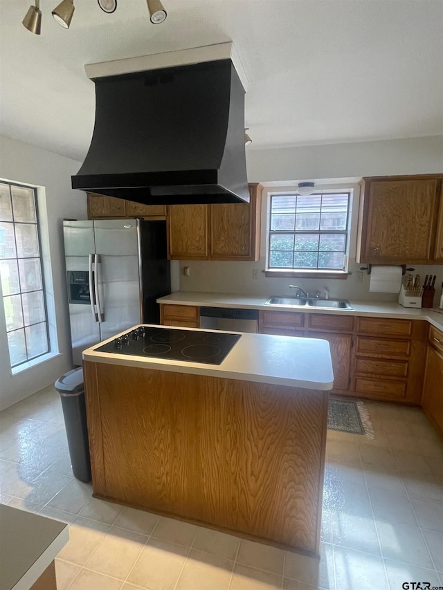 kitchen featuring extractor fan, a center island, sink, and a wealth of natural light