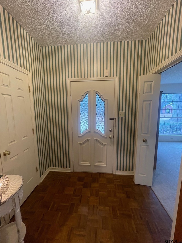 entrance foyer featuring dark parquet flooring and a textured ceiling