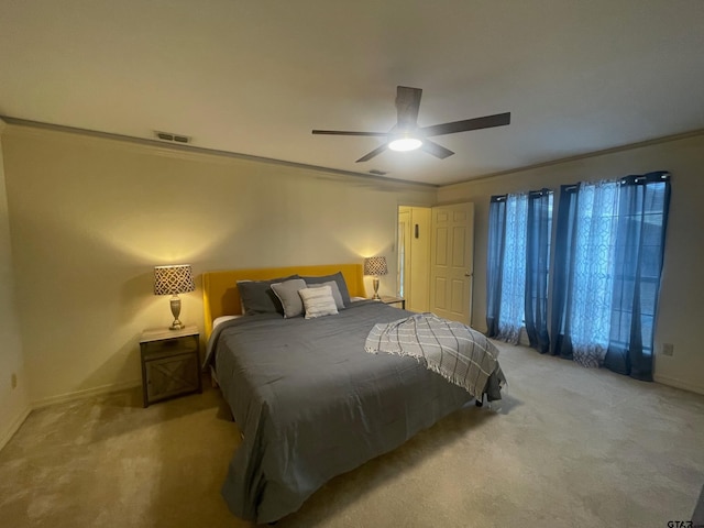 carpeted bedroom with ornamental molding and ceiling fan