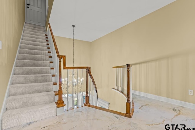 staircase featuring a chandelier