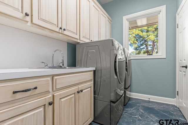 washroom with washer and dryer, cabinets, and sink