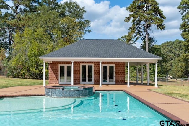 view of pool with french doors, a patio, an in ground hot tub, and an outdoor structure