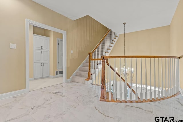 stairs featuring a chandelier